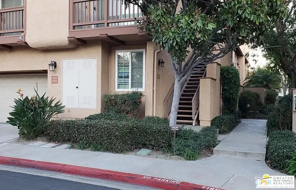 a view of a house with wooden fence and potted plants
