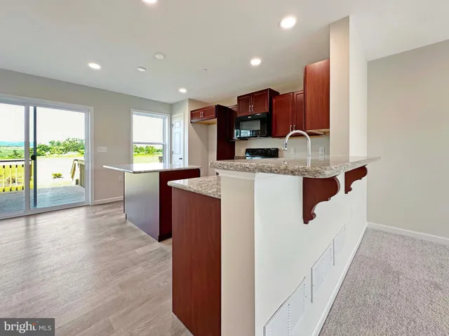 a kitchen with stainless steel appliances granite countertop a sink a stove and a refrigerator