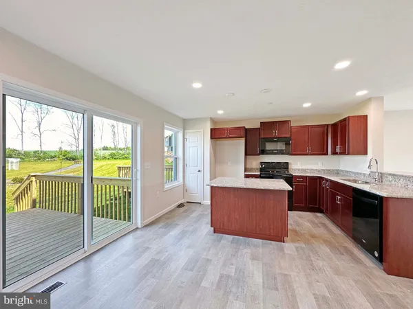 a large kitchen with stainless steel appliances granite countertop a large counter top a refrigerator and a sink