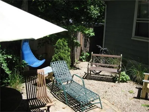 a view of a patio with table and chairs potted plants and floor to ceiling window
