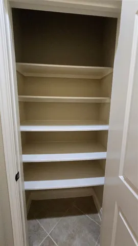 an empty room with wooden floor white walls and windows