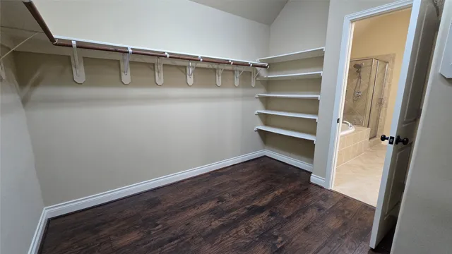 a view of walk in closet with empty racks
