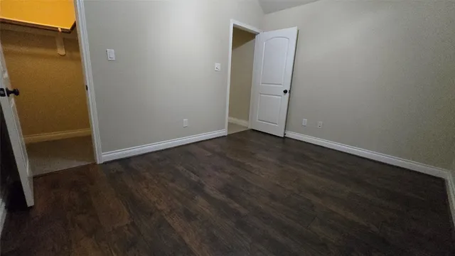 an empty room with wooden floor and a fireplace