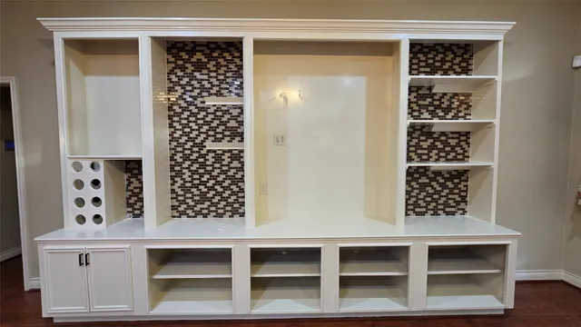 a kitchen with stainless steel appliances kitchen island granite countertop a refrigerator a stove a sink and a wooden floor