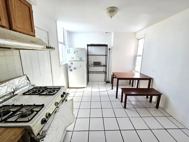 a kitchen with a stove a refrigerator and a table