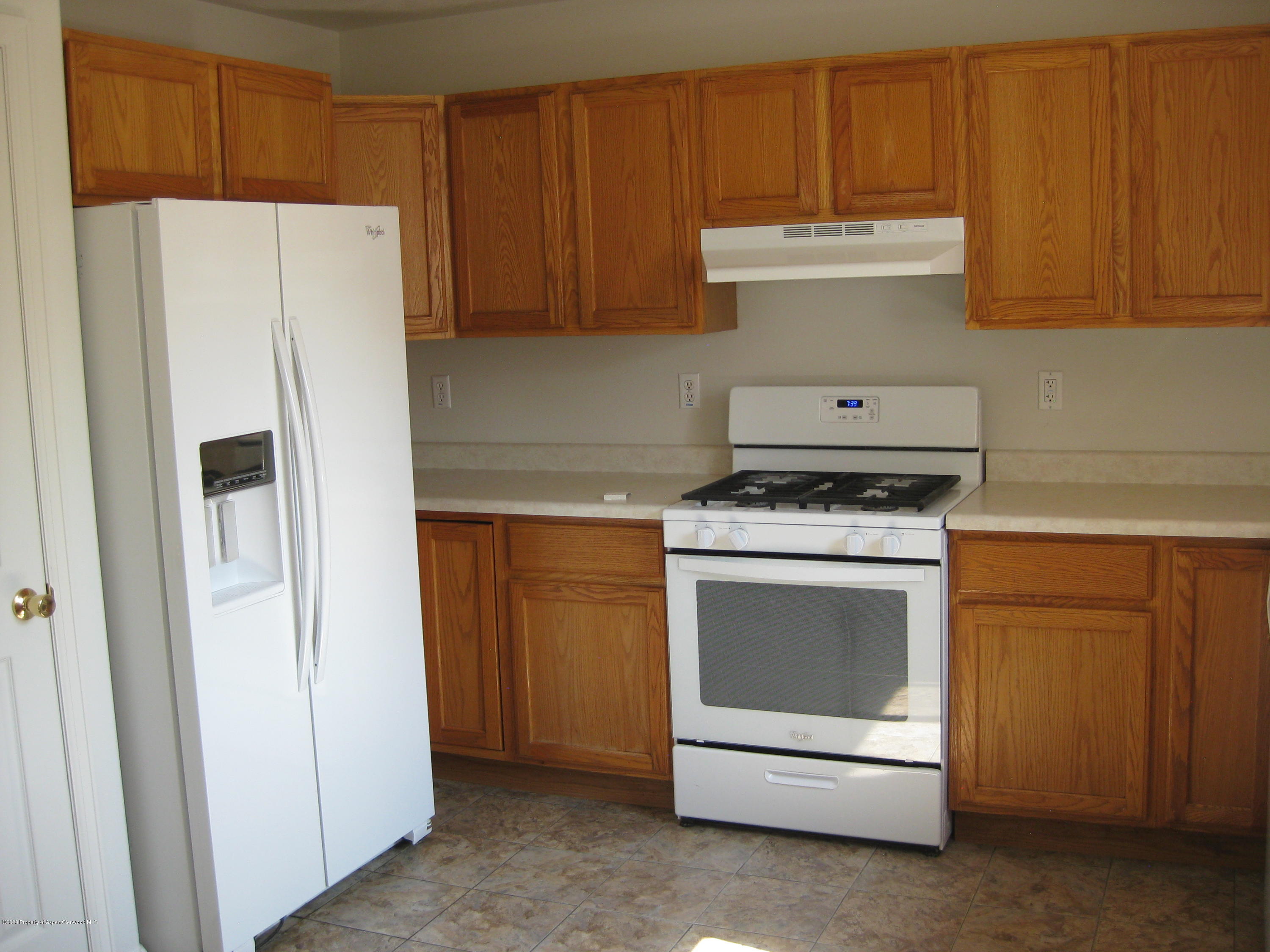 1588 Anvil View Avenue Rifle, CO 81650 - Photo 8 of 15 a white refrigerator freezer and a stove sitting inside of a kitchen with granite countertop white cabinets