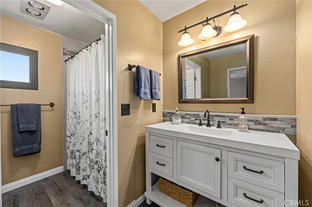 a bathroom with a double vanity sink mirror and shower