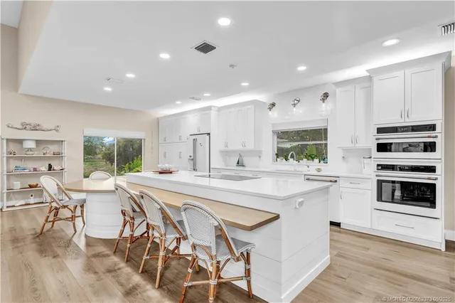 a large kitchen with kitchen island a large island in it
