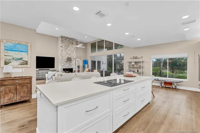 a view of living room with stainless steel appliances kitchen island furniture and a flat screen tv