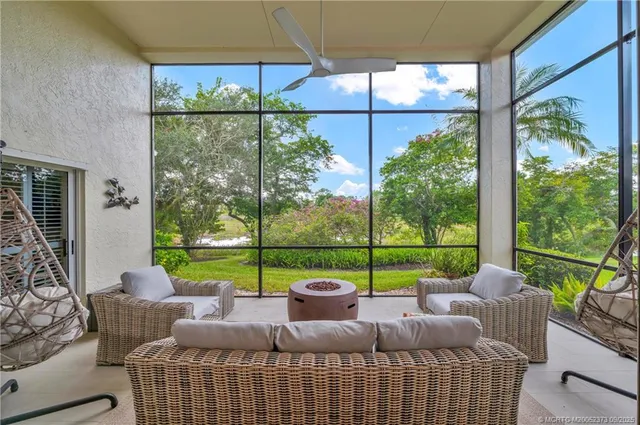 a living room with furniture a lamp and a large window