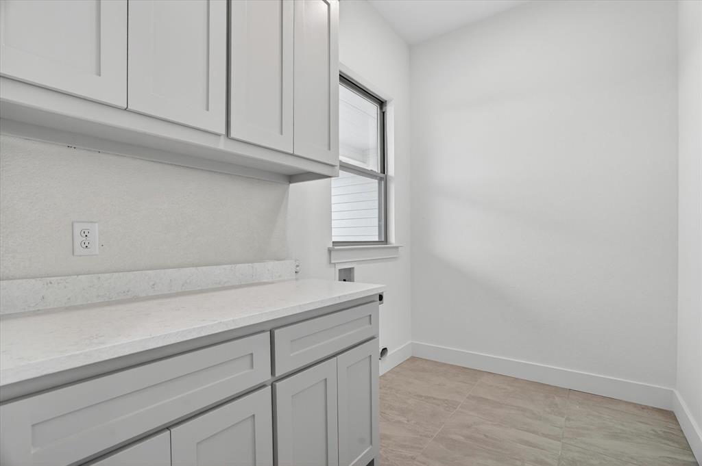 225 Kilkenny Road Poolville, TX 76487 - Photo 27 of 36 Utility room featuring light gray shaker cabinetry, a white countertop, and tiled flooring