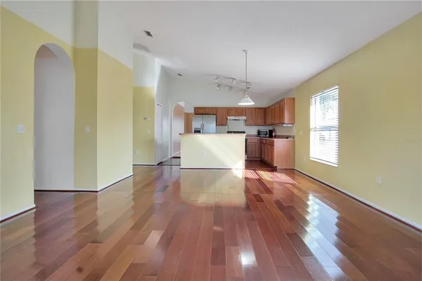 a view of a kitchen with a refrigerator wooden floor and a window