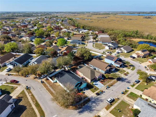 an aerial view of a city with lots of residential buildings and ocean view in back