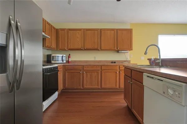 a kitchen with stainless steel appliances granite countertop a refrigerator sink and cabinets