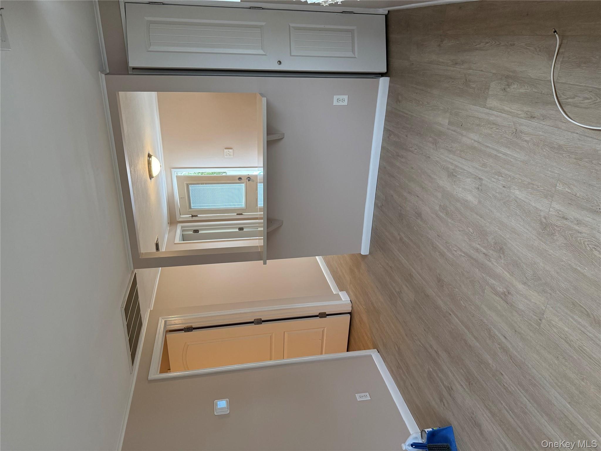 462 Moriches Road St. James, NY 11780 - Photo 11 of 17 Unfurnished living room featuring light wood-style floors and crown molding