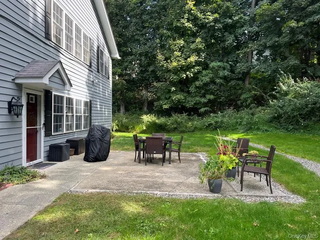 a view of a chair and table in backyard of the house