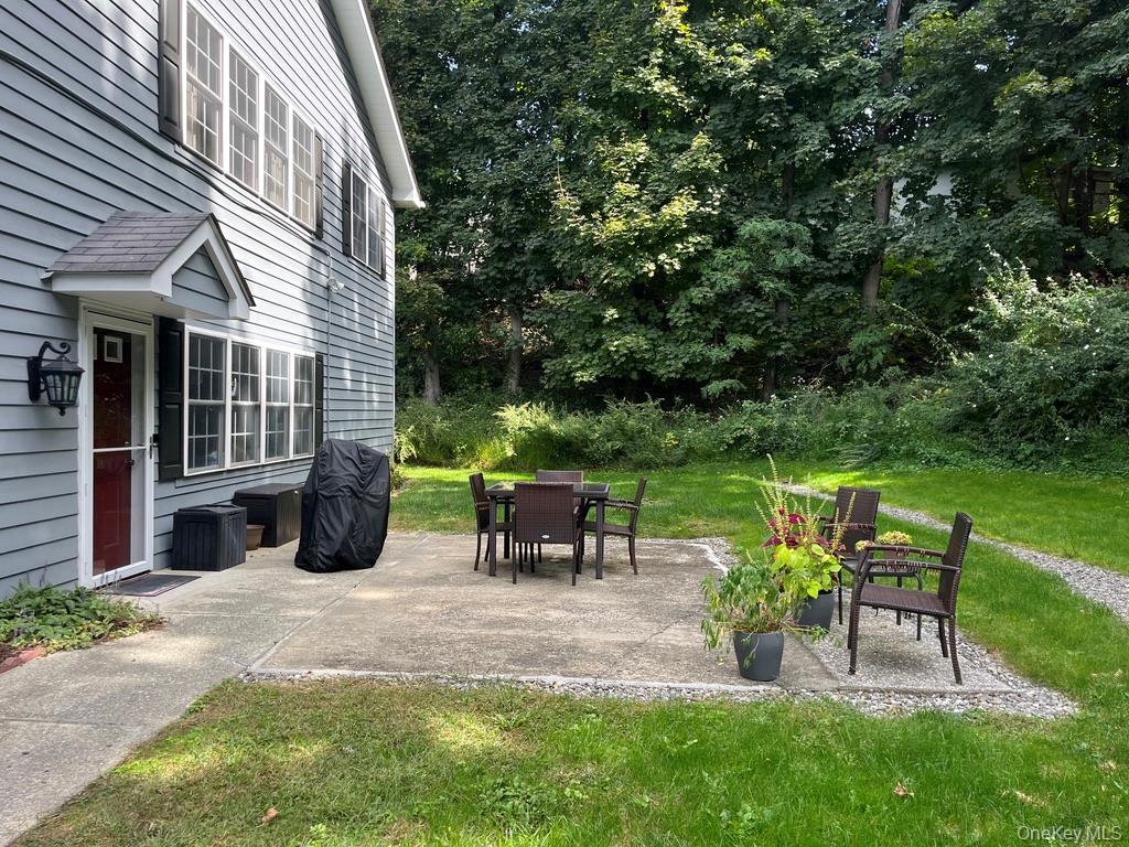 a view of a chair and table in backyard of the house