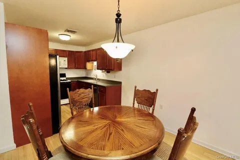a dining room with a table chairs wooden floor and a chandelier