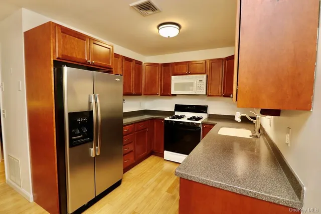 a kitchen with stainless steel appliances granite countertop a refrigerator a sink and a stove