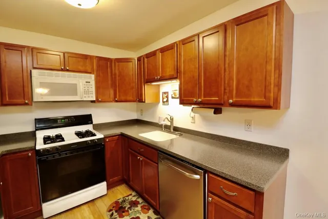 a kitchen with stainless steel appliances granite countertop a sink stove and microwave