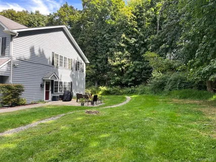 a view of a house with a yard and sitting area