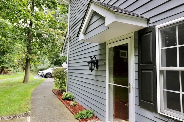 a view of a porch with couches potted plants and floor to ceiling window