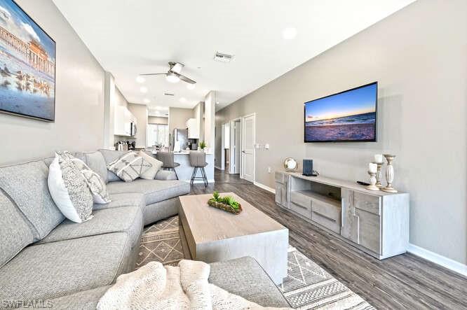 7935 Mahogany Run Lane, Unit 725 Naples, FL 34113 - Photo 2 of 27 a living room with furniture a flat screen tv and kitchen view