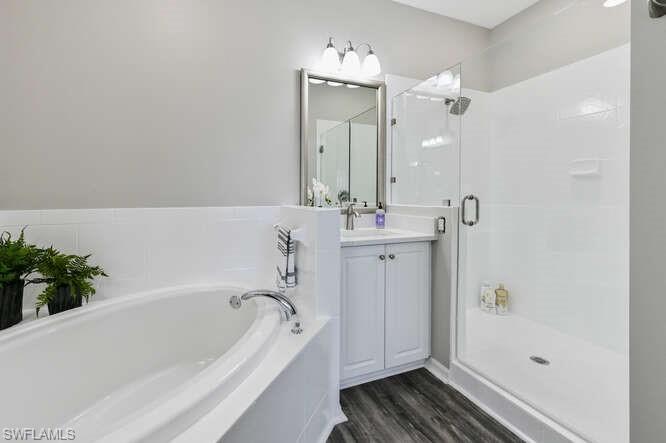 7935 Mahogany Run Lane, Unit 725 Naples, FL 34113 - Photo 8 of 27 a bathroom with a bathtub a sink and a mirror