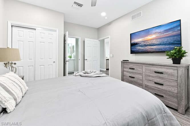 7935 Mahogany Run Lane, Unit 725 Naples, FL 34113 - Photo 9 of 27 a bedroom with a bed and a flat screen tv