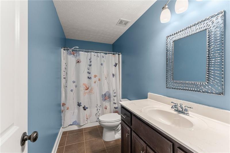 4295 Porter Springs Road Dahlonega, GA 30533 - Photo 24 of 55 a bathroom with a granite countertop sink toilet a mirror a vanity and shower