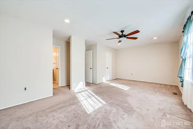 a view of an empty room with a ceiling fan