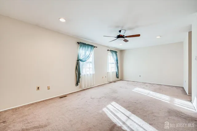 an empty room with fan and windows