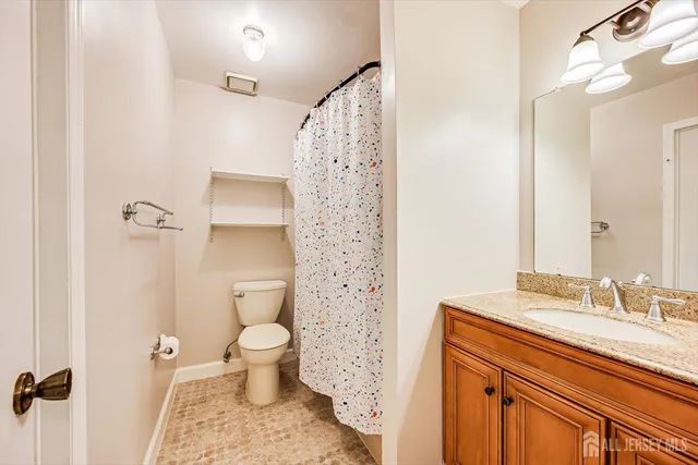 a bathroom with a sink a toilet and shower curtain