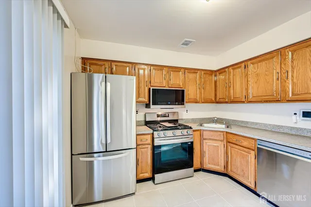 a kitchen with stainless steel appliances a refrigerator stove microwave and sink