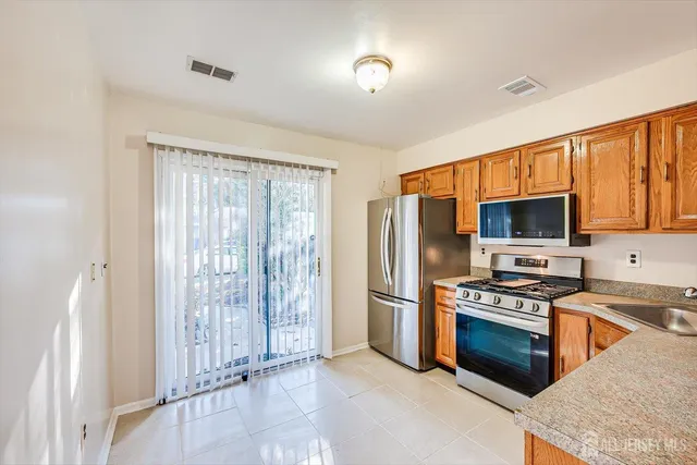a kitchen with stainless steel appliances granite countertop a refrigerator stove and sink
