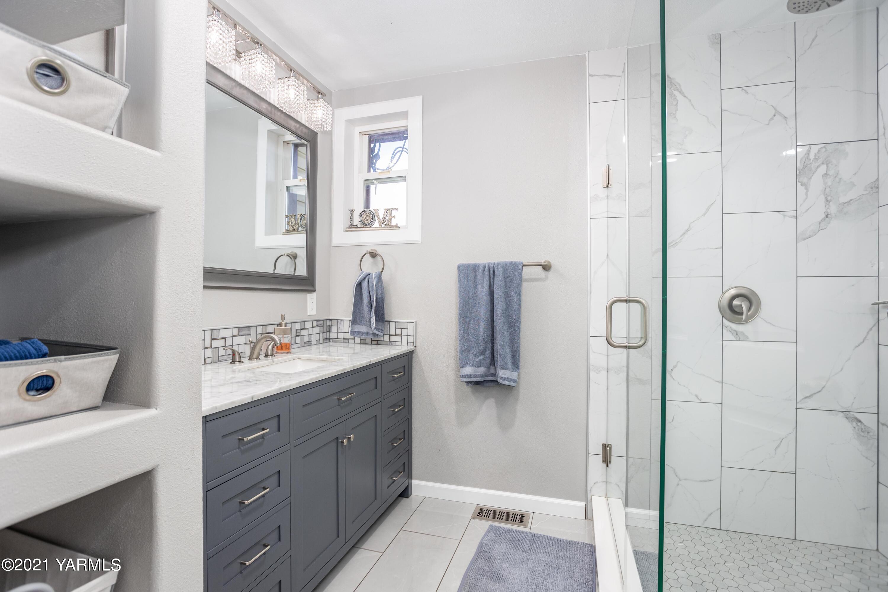 570 Chase Road Grandview, WA 98930 - Photo 18 of 42 a bathroom with a granite countertop sink a mirror and shower