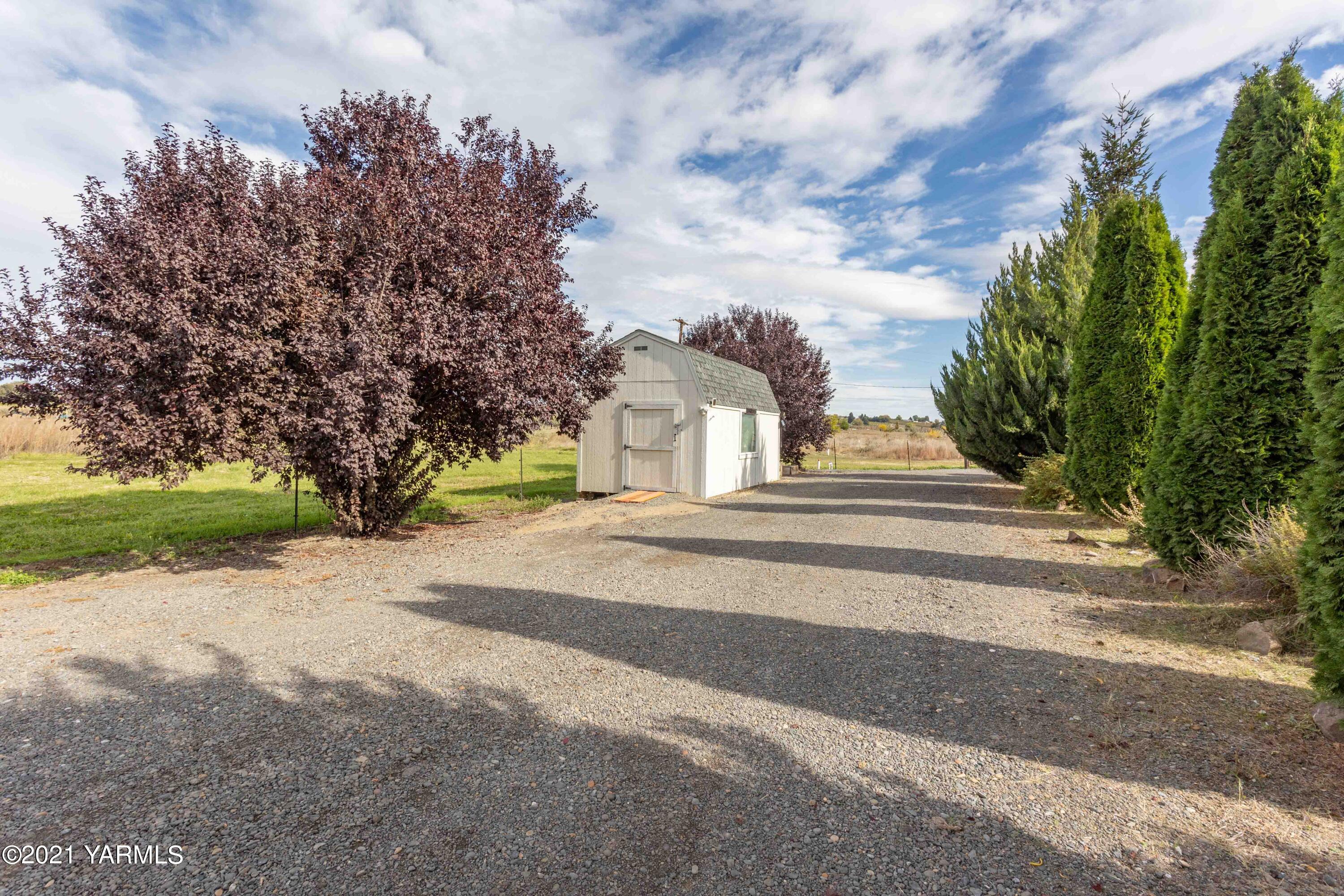 570 Chase Road Grandview, WA 98930 - Photo 40 of 42 a front view of a house with a yard and trees
