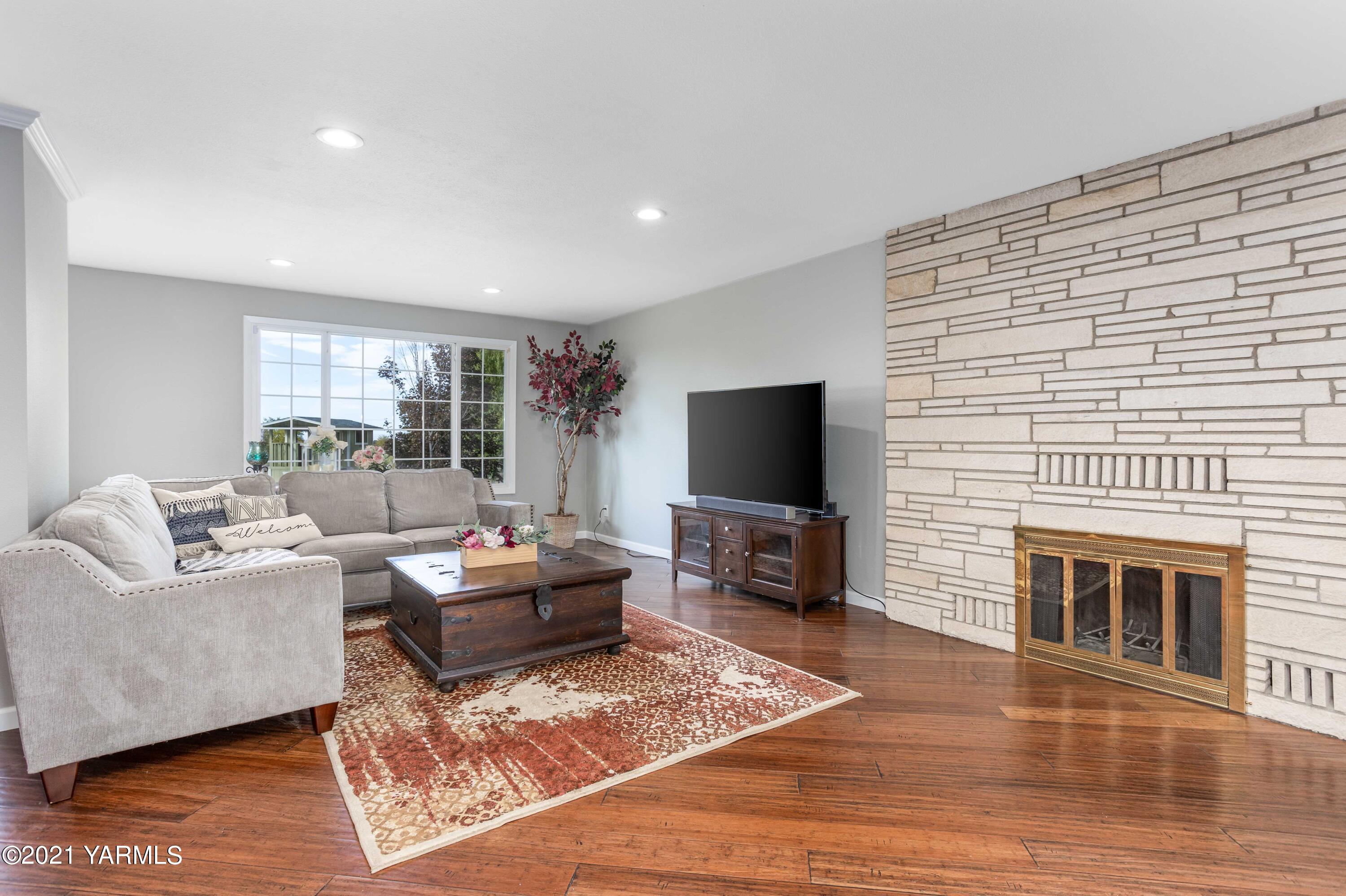 570 Chase Road Grandview, WA 98930 - Photo 5 of 42 a living room with furniture a flat screen tv and a fireplace