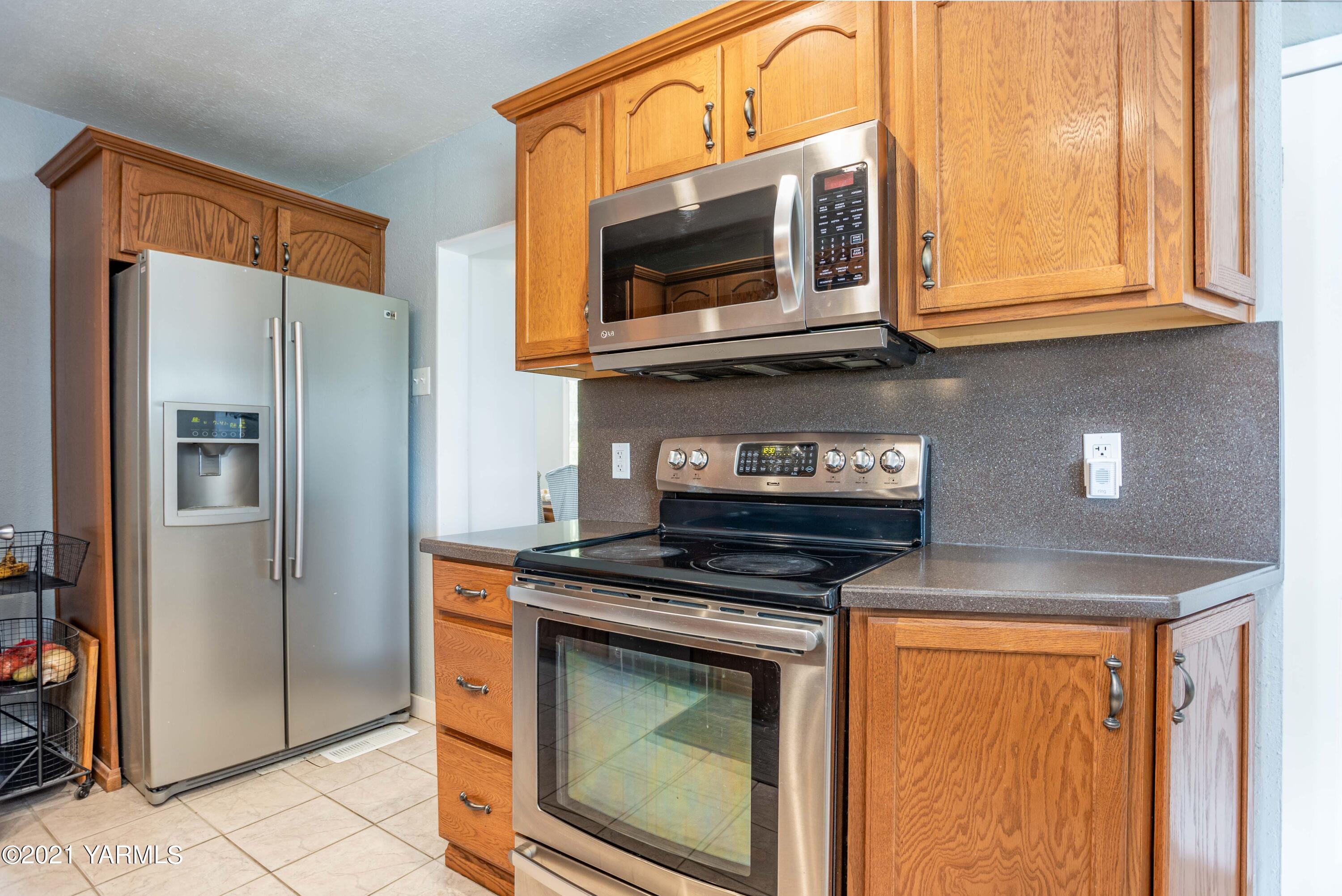 570 Chase Road Grandview, WA 98930 - Photo 10 of 42 a kitchen with stainless steel appliances granite countertop a stove and a microwave