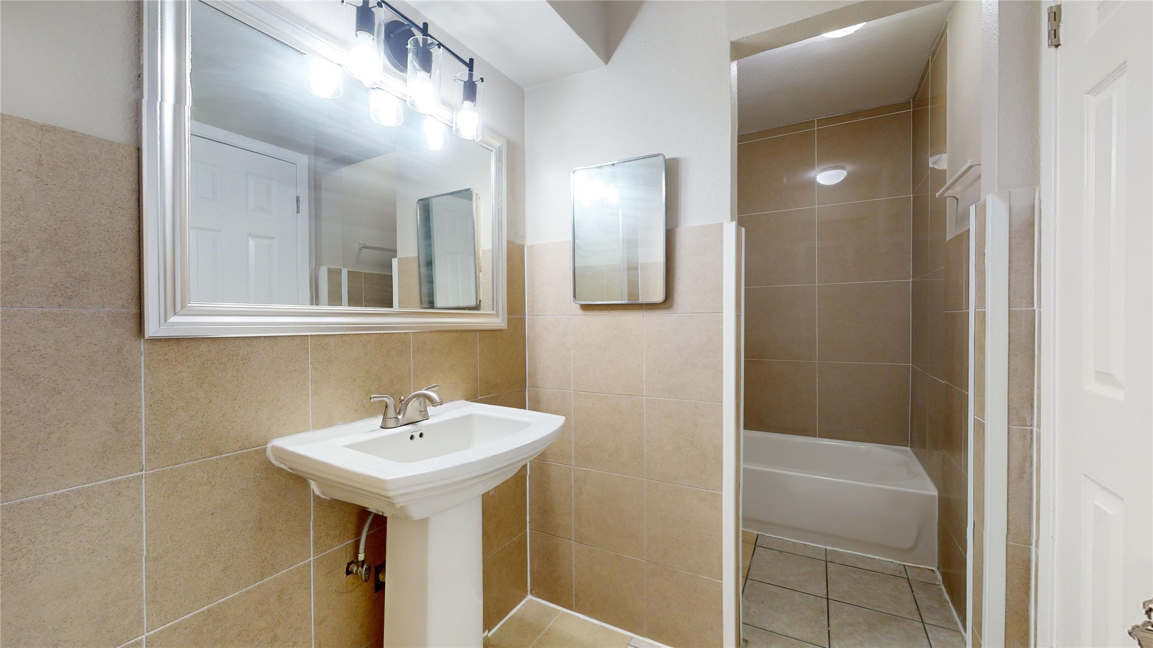 5017 Mallow Street Houston, TX 77033 - Photo 27 of 30 a bathroom with a sink a mirror and a shower