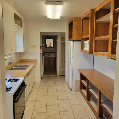 a kitchen with granite countertop white cabinets and sink