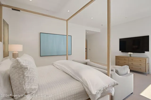 a bedroom with a flat screen television and a bed