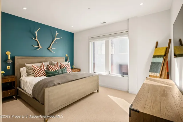 a bedroom with a bed and a large window