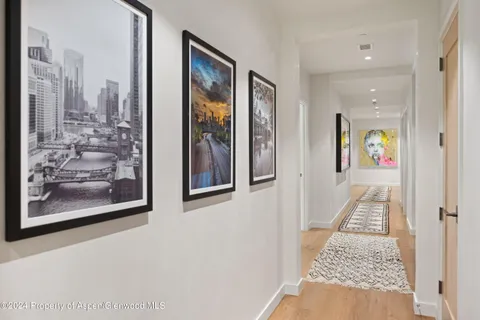 a view of a hallway view with wooden floor and living room