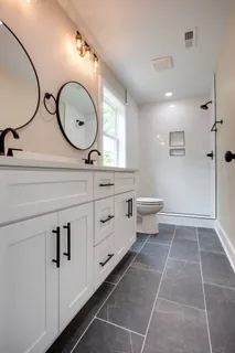a bathroom with a double vanity sink mirror and toilet