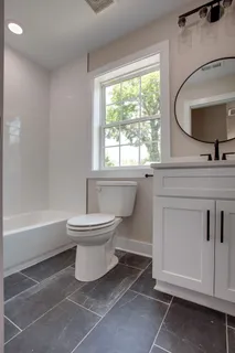a bathroom with a toilet sink a mirror and bathtub