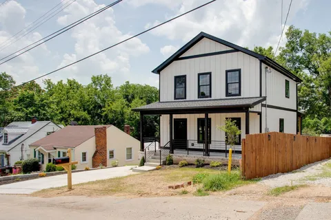 a white house that has a tree in front of it