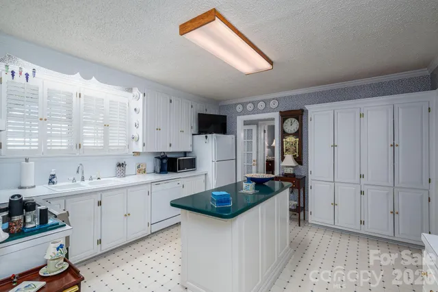 a kitchen that has a sink and chairs in it