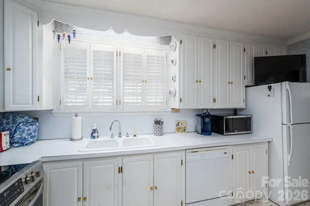 a kitchen with stainless steel appliances a sink a stove a refrigerator a counter space and cabinets