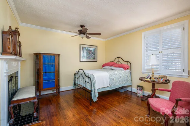 a bedroom with a bed wooden floor and window